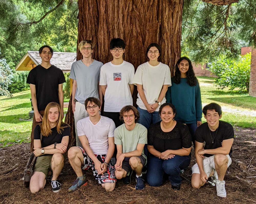 A group photo of students in front of a large tree
